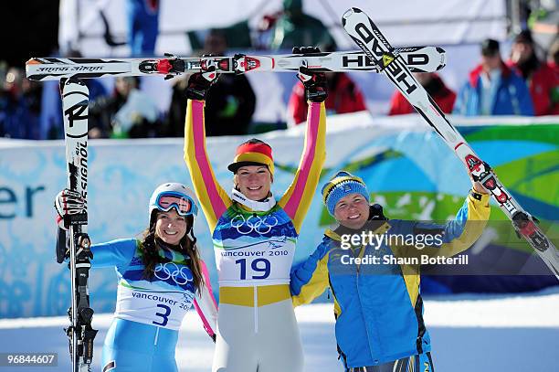 Julia Mancuso of The United States celebrates winning silver, Maria Riesch of Germany gold and Anja Paerson of Sweden bronze after the women's super...