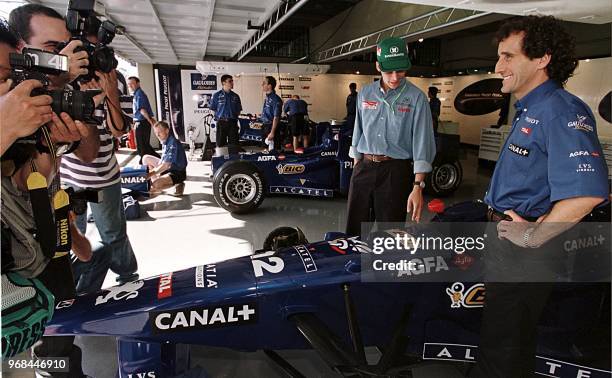 Former Formula One champion Alain Prost, manager of the Prost-Peugeot Formula One team, poses near one of his cars 26 March in the pits of the...