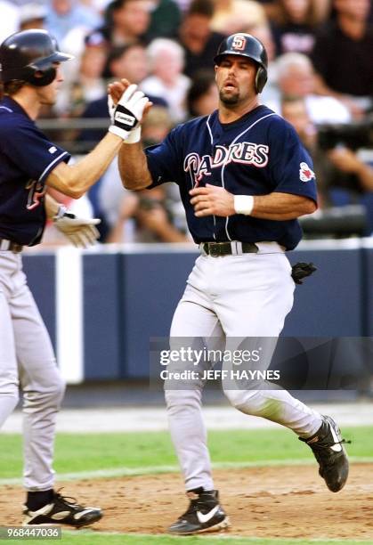 Ken Caminiti of the San Diego Padres is congratulated after scoring in the sixth inning on a single by Wally Joyner against the Atlanta Braves during...