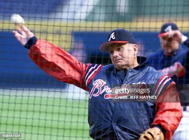 Atlanta Braves manager Bobby Cox throws from behind a protective screen 21 October during during his teams workout at Turner Field in Atlanta, GA....