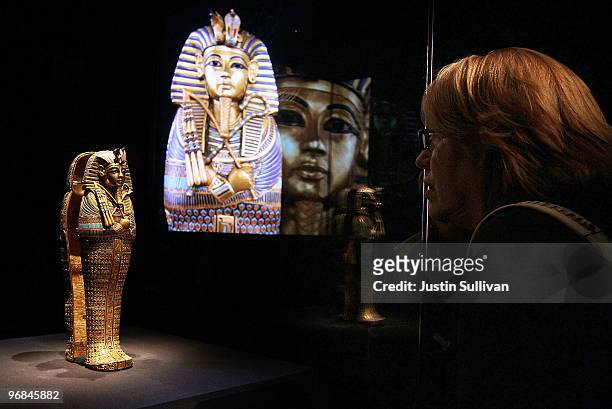Museum patron looks at a coffinette for the viscera of Tutankhamun at the Tutankhamun and the Golden Age of the Pharaohs exhibition at the de Young...