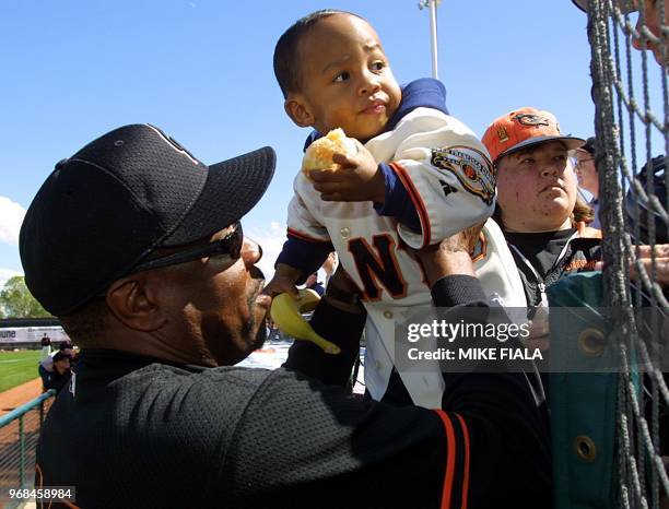 San Francisco Giants' manager Dusty Baker hands his two-year-old son Darren to his wife prior to a Cactus League spring training game against the...
