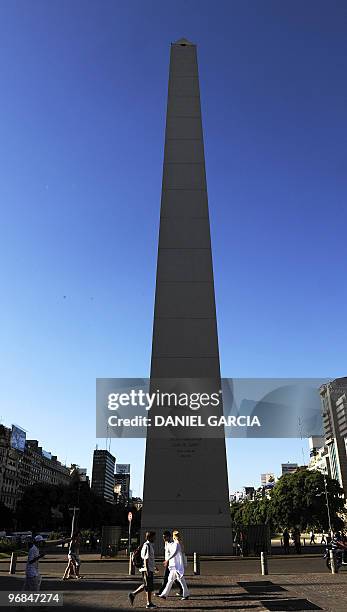 People walk in front of the obelisk which stands at the junction of Avenida 9 de Julio, Corrientes and the Diagonal Norte in Buenos Aires on February...