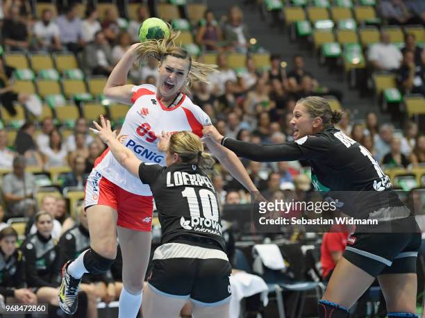 Anna Loerper and Julia Behnke of Germany challenge Kinga Achruk of Poland for the ball during the Women's handball International friendly match...
