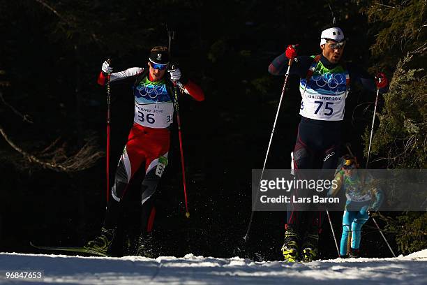 Dominik Landertinger of Austria and Simon Fourcade of France compete during the Biathlon Men's 20 km individual on day 7 of the 2010 Vancouver Winter...