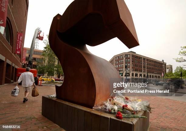 Flowers adorn the base of the Robert Indiana Sculpture "Seven" outside of the Portland Museum of Art in Portland on Friday, May 25, 2018. Indiana,...