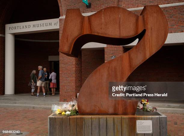 Flowers adorn the base of the Robert Indiana Sculpture "Seven" outside of the Portland Museum of Art in Portland on Friday, May 25, 2018. Indiana,...