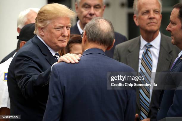 President Donald Trump pats House Veterans Affairs Committee Chairman Phil Roe on the shoulder after Trump signed the Veterans Affairs Mission Act...