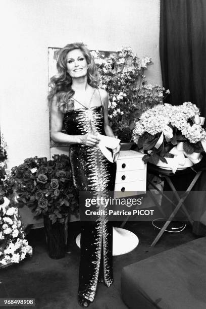 Portrait de la chanteuse Dalida dans sa loge remplie de fleurs de ses admirateurs après un concert à l'Olympia le 20 mars 1981 à Paris, France.