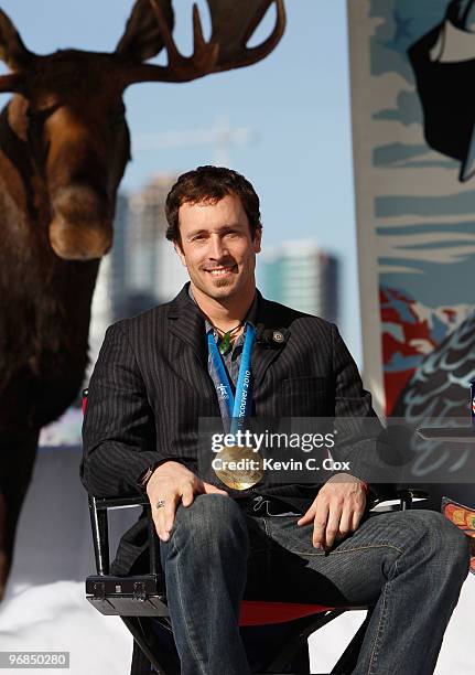 Seth Westcott of the United States wears his Olympic gold medal won in the men's snowboard cross while guest appearing on The Colbert Report with...