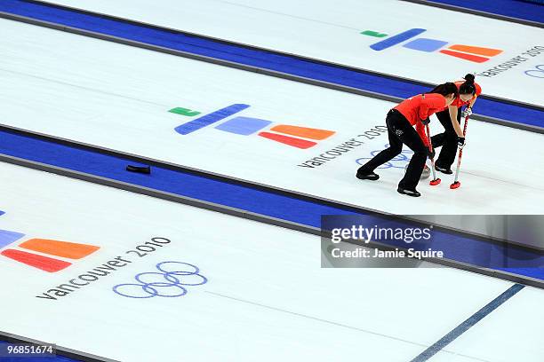 Members of the Chinese team sweep during the women's curling round robin game against Japan on day 7 of the Vancouver 2010 Winter Olympics at...