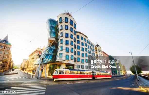 red tram in front of dancing house (tančící dům) in the morning. prague - prague tram stock pictures, royalty-free photos & images