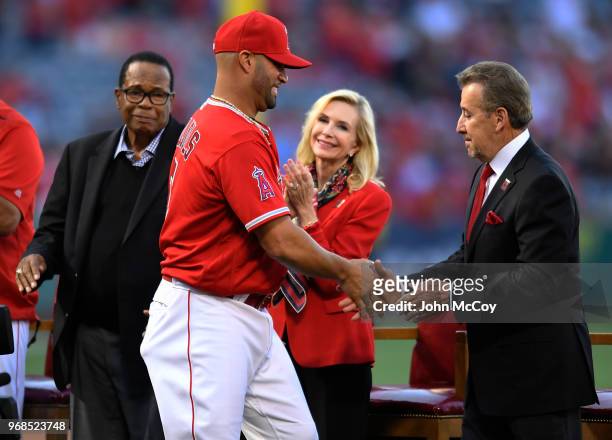Hall of fame player Rod Carew watches as Albert Pujols of the Los Angeles Angels of Anaheim is congratulated by team owner Arte Moreno and his wife...