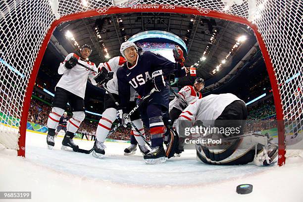 Ryan Malone of The United States scores a goal in the second period against goalie Jonas Hiller of Switzerland during the ice hockey men's...