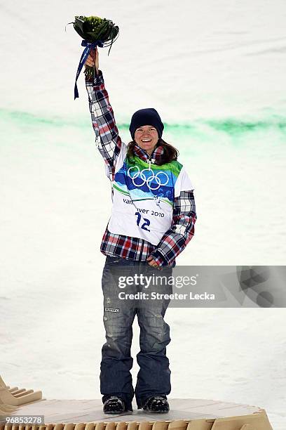 Kelly Clark of the United States celebrates winning the bronze medal during the flower ceremony for the Snowboard Women's Halfpipe final on day seven...