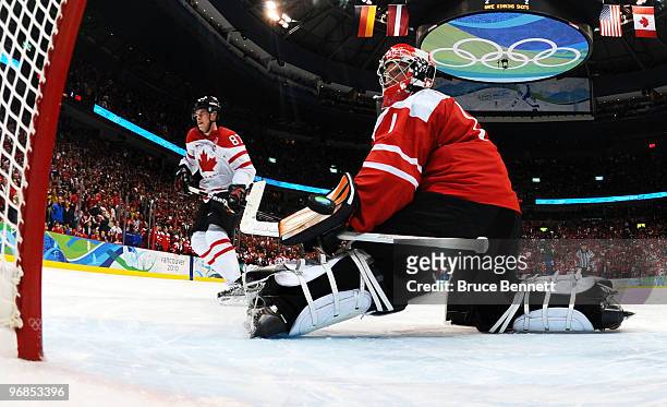 Sidney Crosby of Canada scores the game-winning goal against Jonas Hiller of Switzerland during the ice hockey men's preliminary game between...