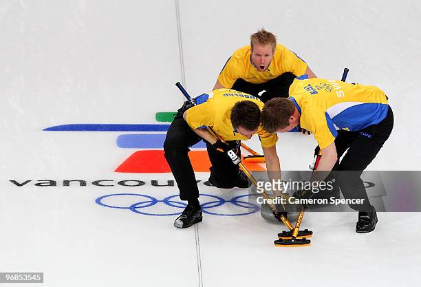 Skip Niklas Edin of Sweden instructs teammates Fredrik Lindberg and Viktor Kjell during the men's curling round robin game between Great Britain and...