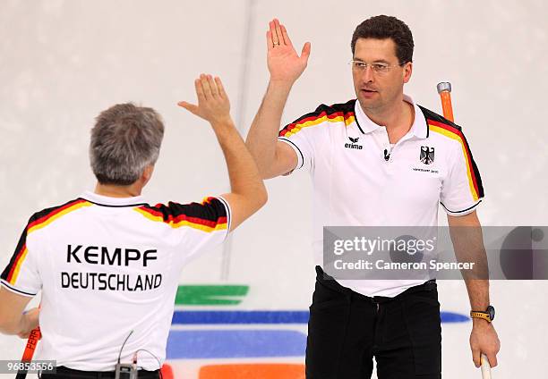 Germany skip Andy Kapp celebrates winning a game with teammate Andreas Kempf during the men's curling round robin game between Germany and the United...