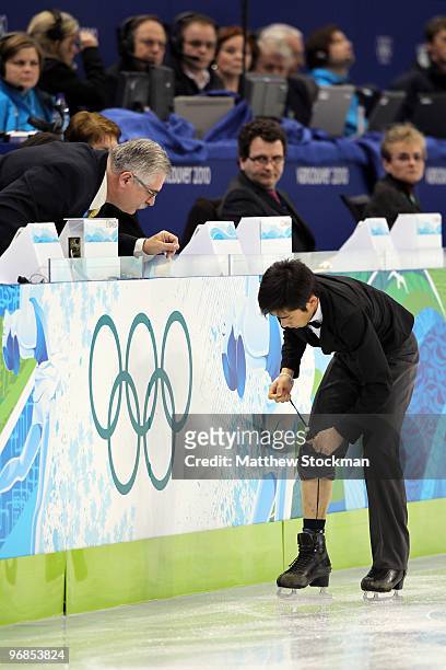 Nobunari Oda of Japan ties his laces as he competes in the men's figure skating free skating on day 7 of the Vancouver 2010 Winter Olympics at the...