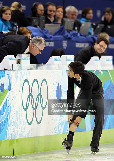 Nobunari Oda of Japan ties his laces as he competes in the men's figure skating free skating on day 7 of the Vancouver 2010 Winter Olympics at the...