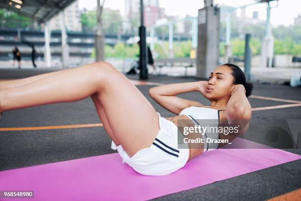 junge schöne afroamerikanische frau tun sit ups - bauchmuskel stock-fotos und bilder