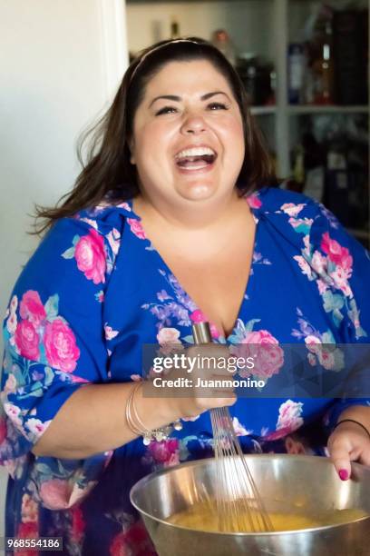 smiling mid adult woman cooking - voluptuous stock pictures, royalty-free photos & images