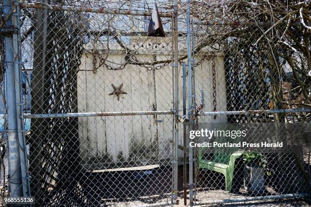 The backyard of Robert Indiana's Vinalhaven home is fenced off and locked Wednesday, May 23, 2018. Indiana died in his home last week.