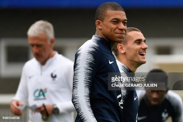 French forward Kylian Mbappe and French forward Antoine Griezmann react as they take part in a training session at the French national football...