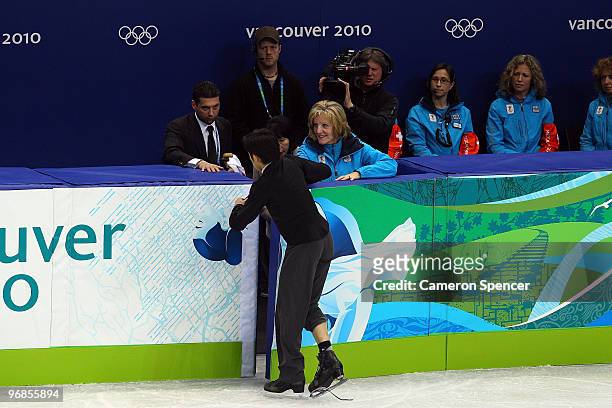 Nobunari Oda of Japan leaves to tie his laces as he competes in the men's figure skating free skating on day 7 of the Vancouver 2010 Winter Olympics...