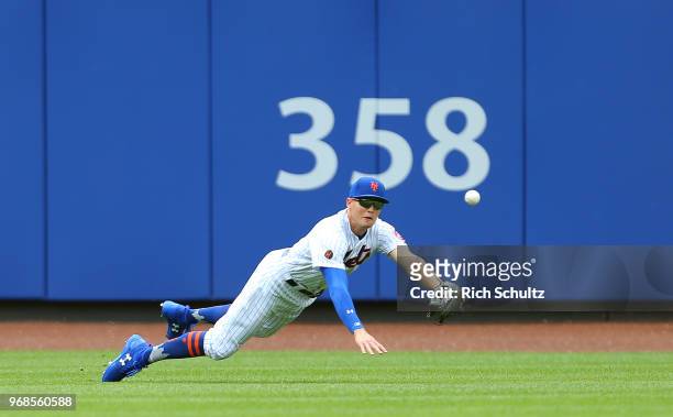 Left fielder Brandon Nimmo of the New York Mets dives but can't make a catch on a ball hit by Chris Davis of the Baltimore Orioles for a single...