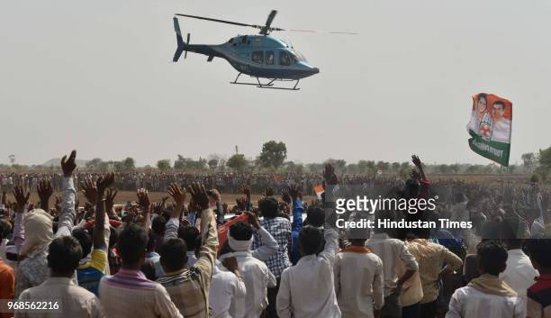 Farmers waves at Congress president Rahul Gandhi as he leaves in helicopter after addressing 'Kisan Samriddhi Sankalp' rally in Pipliya Mandi at...