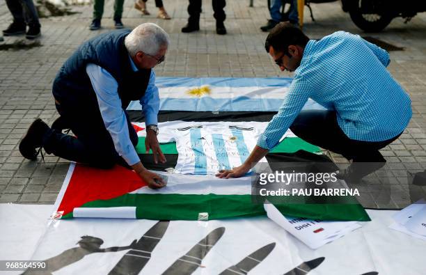 Two pro-Palestine activists place a jersey of Argentina's national football team with a text reading "Thanks for being on the right side of history"...
