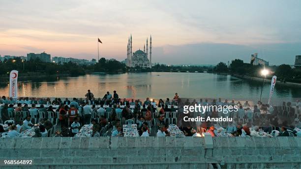 People attend an iftar meal organized by Turkish Red crescent on Taskopru bridge in Adana, Turkey on June 6, 2018.