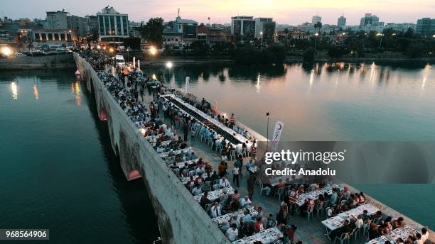 People attend an iftar meal organized by Turkish Red crescent on Taskopru bridge in Adana, Turkey on June 6, 2018.