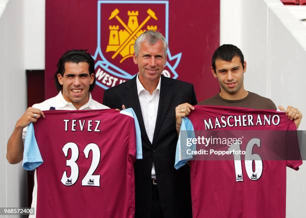 Left to right, Carlos Tevez, West Ham manager Alan Pardew and Javier Mascherano pose with their squad numbers during a West Ham United press...