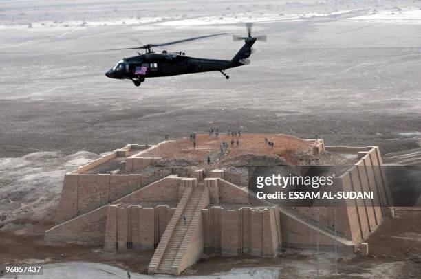 Army helicopter flies over the stepped Ziggurat temple, a three-tiered edifice dating back to 2113 BC, in the ancient city of Ur in southern Iraq on...