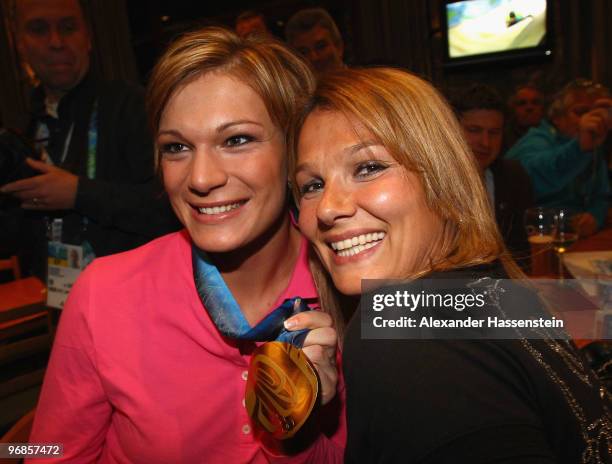 Gold medalist Maria Riesch of Germany poses with Olympic gold medalist swimmer Franziska van Almsick and her gold medal for the women's Super...