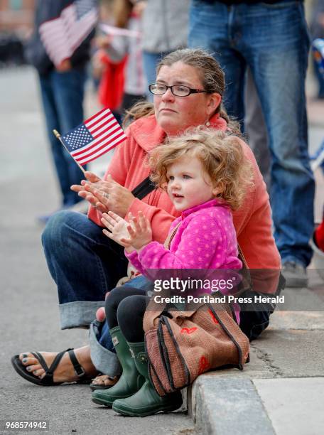 Mary Tobin, left, and her daughter Orla applaud as they watch the Memorial Day parade Monday, May 28, 2018 in Portland, Maine.
