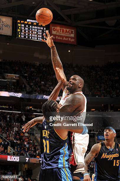 Shaquille O'Neal of the Cleveland Cavaliers shoots over Nene and Carmelo Anthony of the Denver Nuggets during the game on February 18, 2010 at...