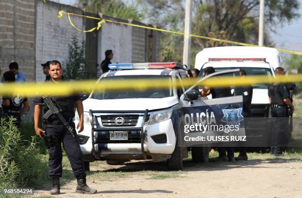 Ministerial police officers secure the area where a clandestine common grave was found, at the Lomas del Aeropuerto neighborhood in El Salto...