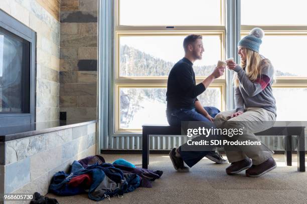 young couple relax after a day of skiing - ski lodge stock pictures, royalty-free photos & images