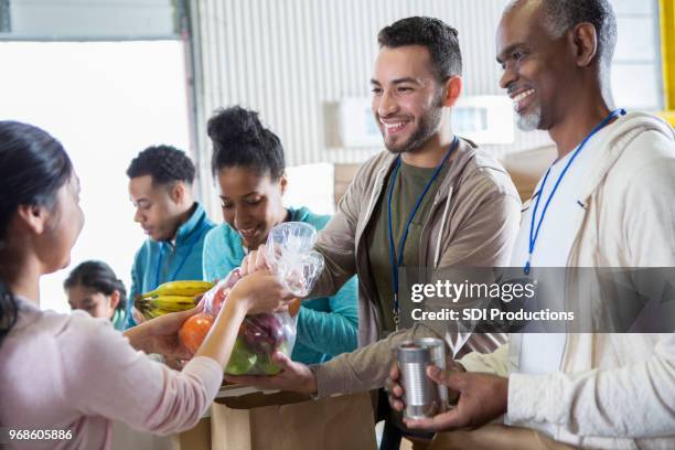 alegres voluntarios reciben donaciones durante la comida - food pantry fotografías e imágenes de stock