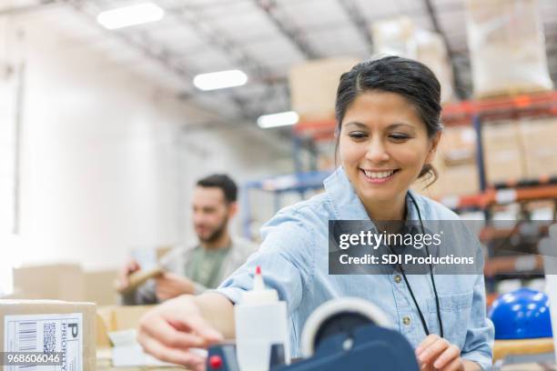 cheerful distribution warehouse employee tapes packages - independent record label stock pictures, royalty-free photos & images