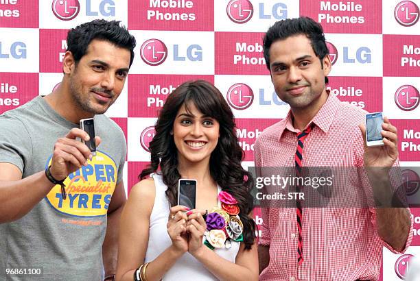 Indian Bollywood film personalities John Abraham , Genelia D'souza and Abhay Deol pose with LG mobile mobiles during a function in New Delhi on...