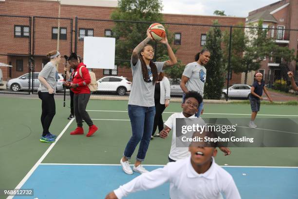 Seimone Augustus of the Minnesota Lynx participates in a community event giving away shoes and socks at Payne Elementary in Washington, DC on Jun 6,...