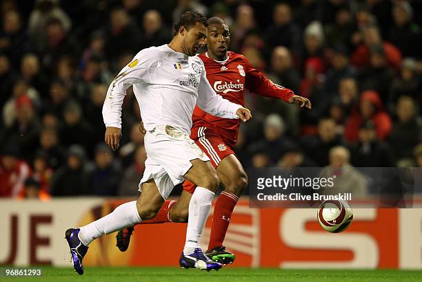 Ryan Babel of Liverpool holds off a challenge from Ricardo Vilana of Unirea Urziceni during the UEFA Europa League Round 32 first leg match between...