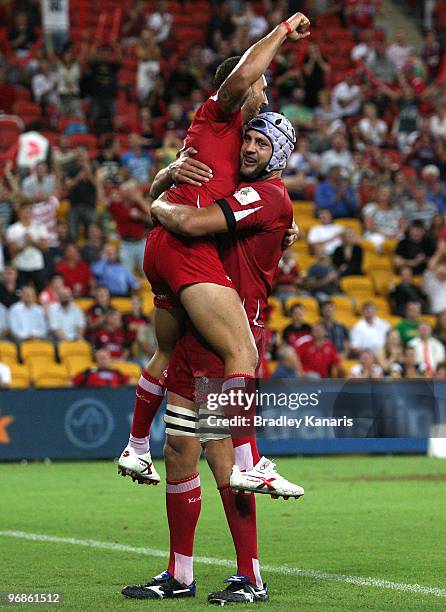 Quade Cooper of the Reds celebrates with team mate Adam Byrnes after scoring a try during the round two Super 14 match between the Reds and the...