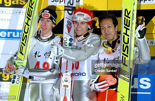 2nd place Martin Koch, winner Andreas Widholzl of Austria and 3rd place Noriaki Kasai of Japan pose for photographs on the podium after FIS World Cup...