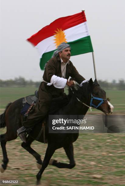 Kurdish man holds his flag as he rides a horse during a traditional wedding ceremony in the Kurdish city of Arbil, northern Iraq, on February 18,...