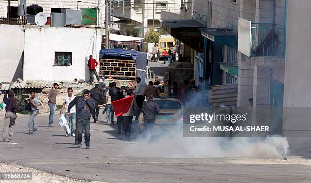 Palestinian protesters take cover from tear gas fired by Israeli forces during a demonstration against Israel's separation barrier, in the West Bank...